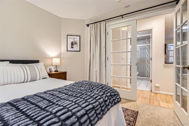 16179 W 70th Pl, Arvada, CO 80007 - bedroom featuring french doors, light wood finished floors, and ensuite bath