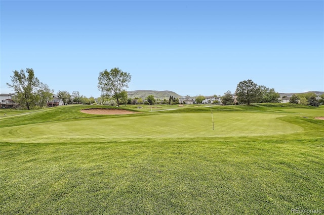 16179 W 70th Pl, Arvada, CO 80007 - view of community featuring golf course view, a putting area, a mountain view, and a lawn