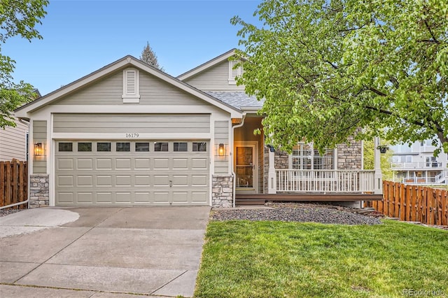 16179 W 70th Pl, Arvada, CO 80007 - view of front of property with stone siding, concrete driveway, a garage, and covered porch
