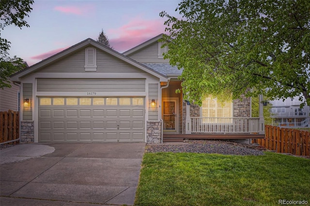 16179 W 70th Pl, Arvada, CO 80007 - view of front of home featuring stone siding, concrete driveway, a porch, and a garage
