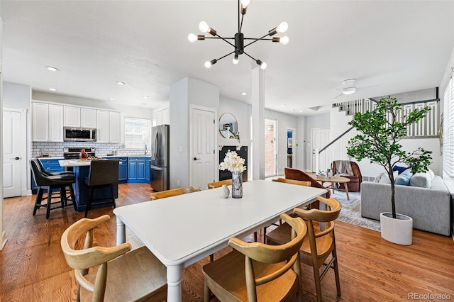 1063 Roslyn Ct, Denver, CO 80230 - dining room with light wood-style flooring, stairway, a chandelier, ceiling fan, and recessed lighting