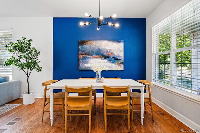 1063 Roslyn Ct, Denver, CO 80230 - dining space featuring wood finished floors, a chandelier, plenty of natural light, and baseboards