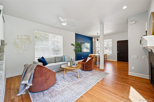 1063 Roslyn Ct, Denver, CO 80230 - living area featuring a glass covered fireplace, light wood-style flooring, baseboards, and a ceiling fan