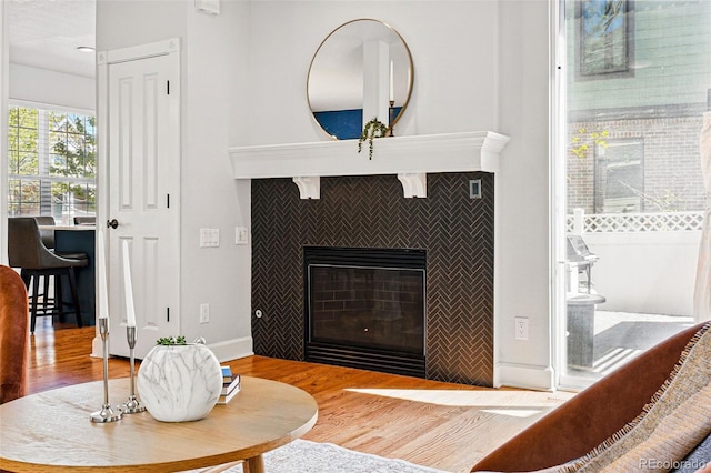 1063 Roslyn Ct, Denver, CO 80230 - living area with wood finished floors, a tiled fireplace, and baseboards