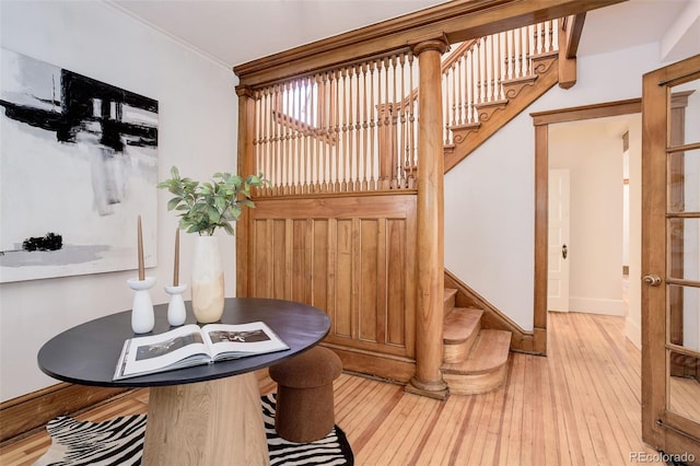 dining room with stairs, wood-type flooring, baseboards, and crown molding