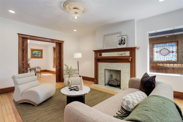 living area with hardwood / wood-style flooring, baseboards, recessed lighting, and a fireplace