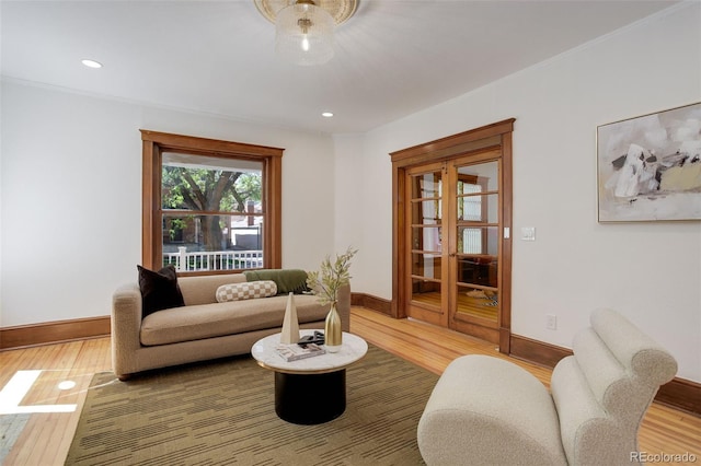 living area with light wood-type flooring, baseboards, recessed lighting, and ornamental molding