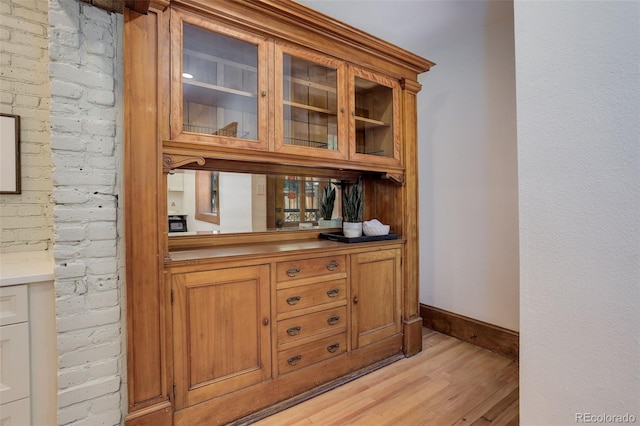 bar area featuring light wood-style flooring and baseboards