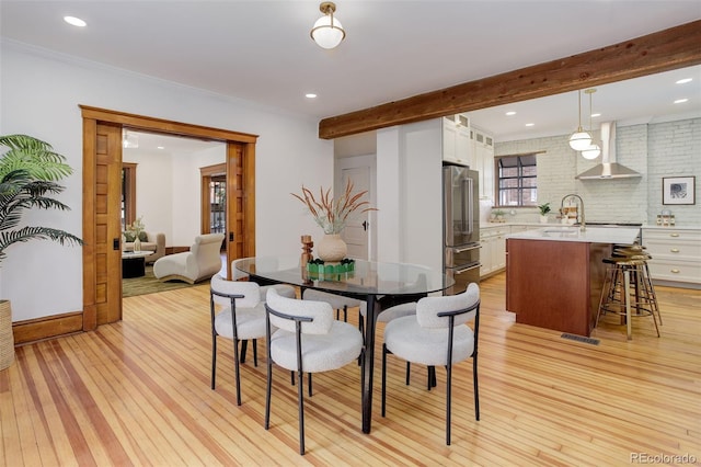 dining room with light wood-type flooring, beamed ceiling, recessed lighting, and crown molding
