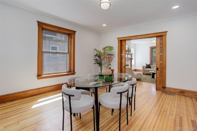 dining space with baseboards, light wood-type flooring, recessed lighting, and crown molding