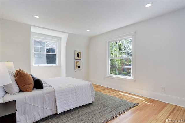 bedroom featuring wood finished floors, recessed lighting, and baseboards
