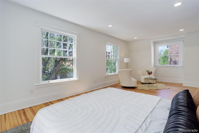 bedroom featuring multiple windows, wood finished floors, baseboards, and recessed lighting
