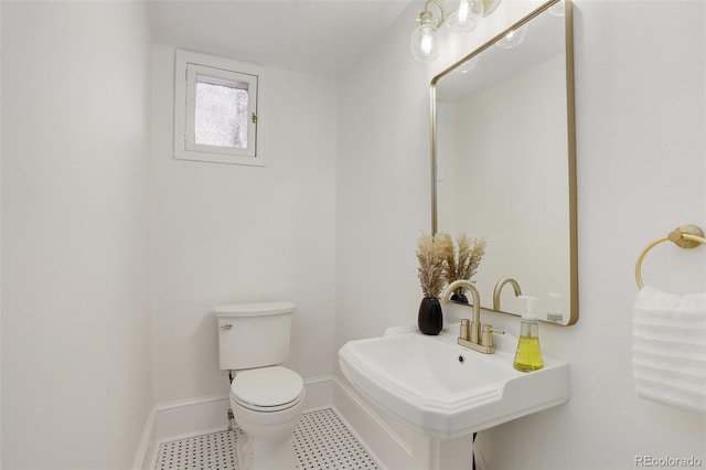 bathroom with a sink, toilet, baseboards, and tile patterned floors