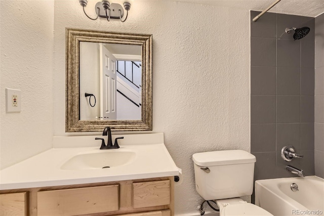 full bathroom featuring tiled shower / bath combo, toilet, and vanity