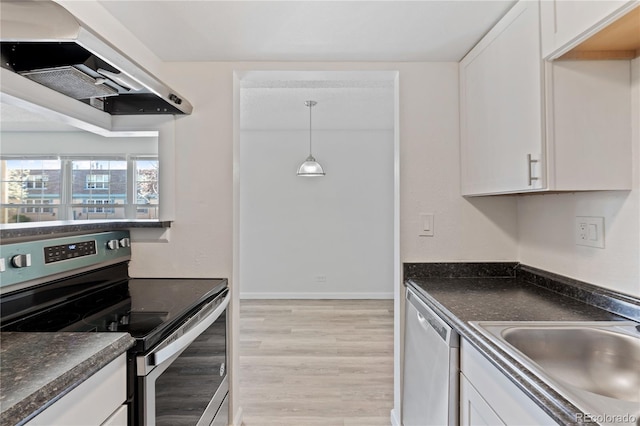 kitchen with appliances with stainless steel finishes, under cabinet range hood, dark countertops, and white cabinets