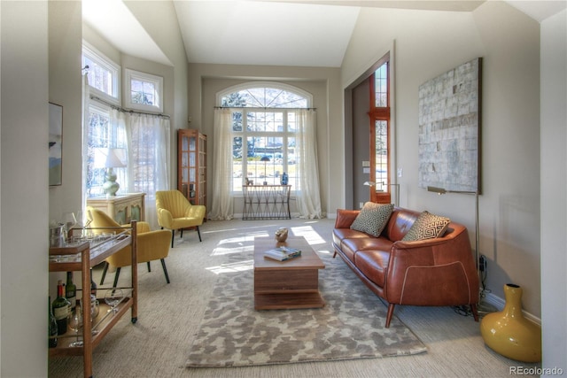 interior space with high vaulted ceiling and light colored carpet