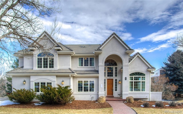 view of front of house featuring a tiled roof and stucco siding