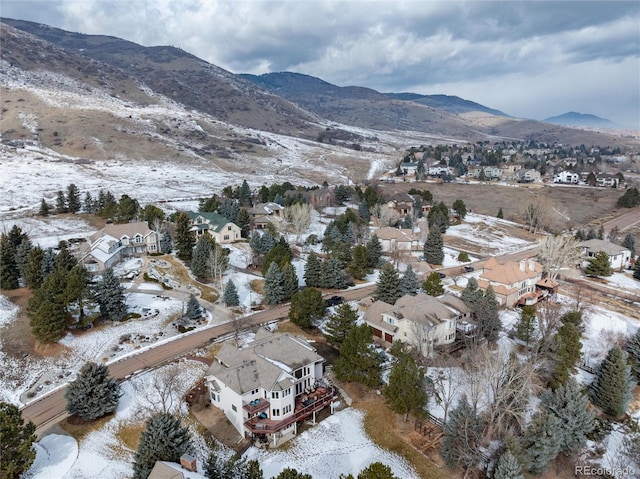 snowy aerial view featuring a residential view and a mountain view