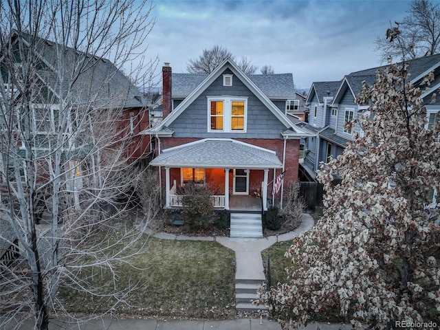 view of front of property with covered porch and a front lawn