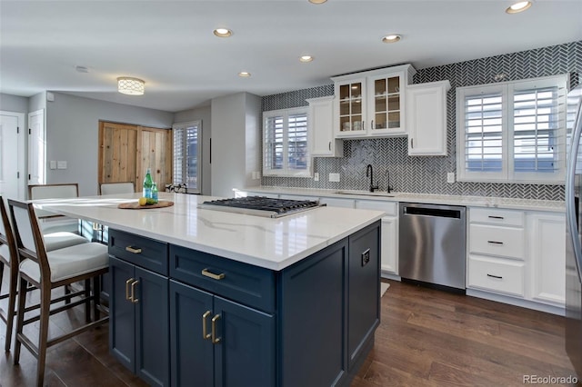 kitchen with dark hardwood / wood-style floors, blue cabinets, white cabinetry, sink, and stainless steel appliances