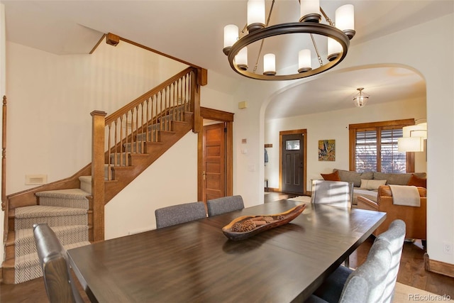 dining room with dark hardwood / wood-style floors and a notable chandelier