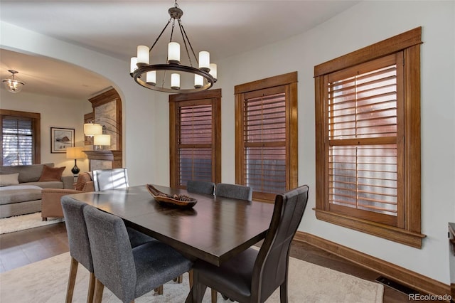 dining space with dark hardwood / wood-style flooring and a notable chandelier