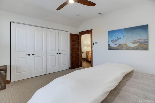 carpeted bedroom featuring vaulted ceiling, ceiling fan, and a closet