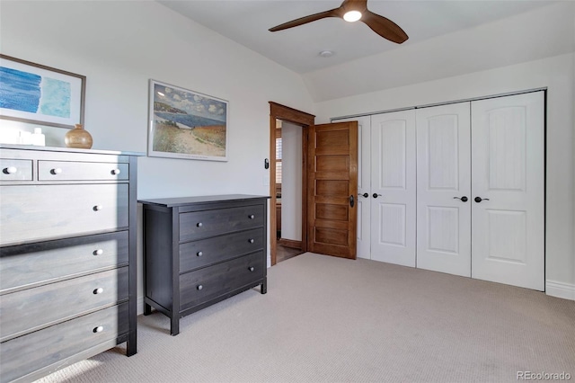 carpeted bedroom with vaulted ceiling, a closet, and ceiling fan