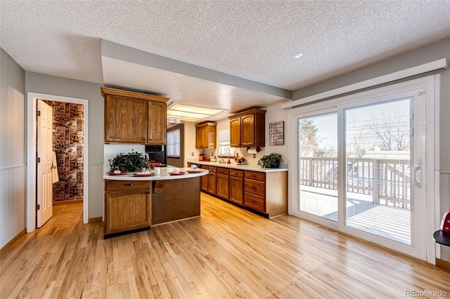 kitchen featuring a textured ceiling and light hardwood / wood-style floors