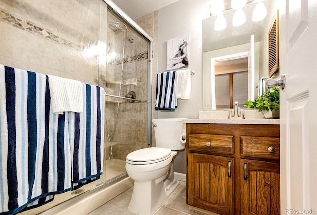 bathroom featuring tile patterned flooring, vanity, toilet, and a shower with door