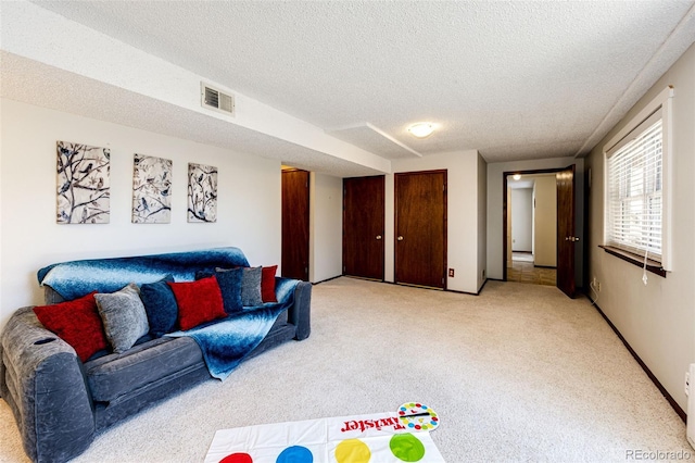 living room with a textured ceiling and light colored carpet