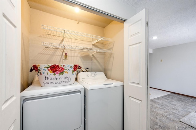 laundry area featuring washing machine and clothes dryer and a textured ceiling