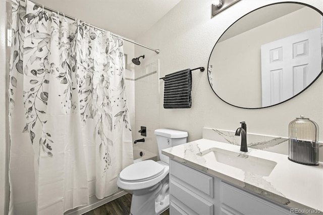 full bath with wood finished floors, vanity, shower / bathtub combination with curtain, and toilet