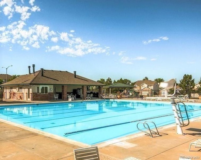 community pool with a patio area and a gazebo