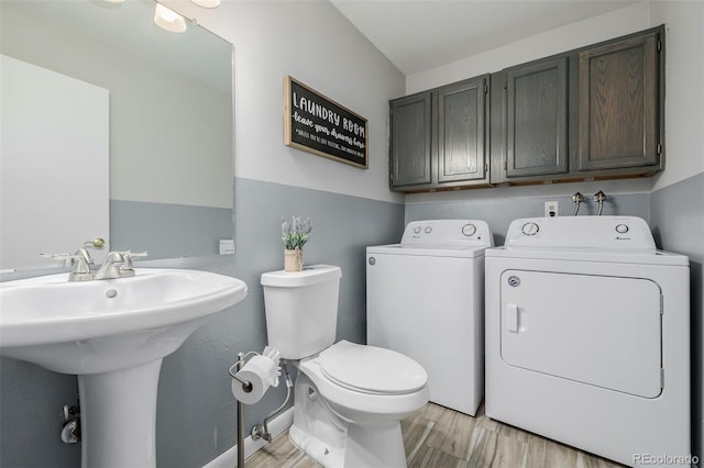 bathroom featuring toilet, hardwood / wood-style flooring, sink, and washer and clothes dryer