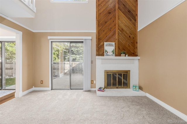 unfurnished living room with crown molding, carpet floors, high vaulted ceiling, and a brick fireplace