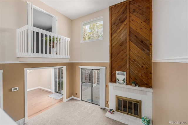 living room featuring a brick fireplace and wood-type flooring