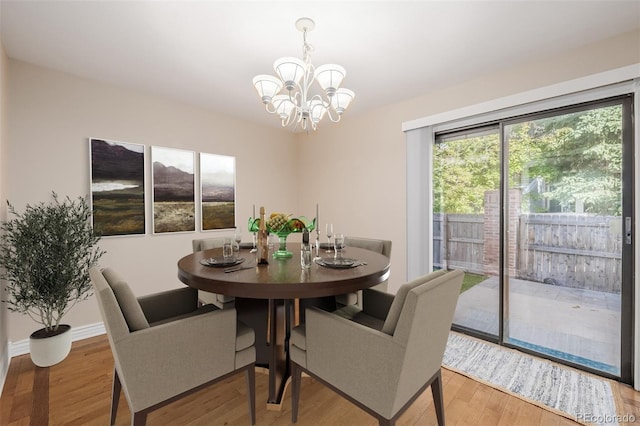 dining area with wood-type flooring and an inviting chandelier