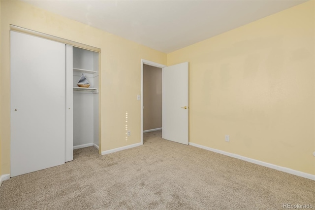 unfurnished bedroom with a closet and light colored carpet