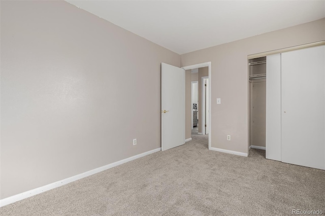 unfurnished bedroom featuring a closet and light colored carpet