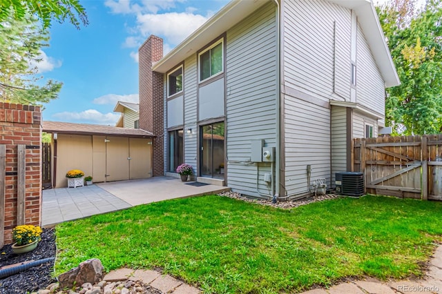 back of property featuring a yard, central air condition unit, and a patio