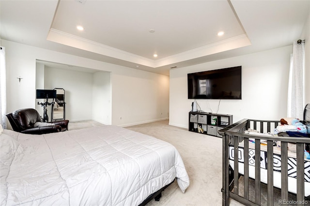 bedroom with carpet floors, ornamental molding, and a tray ceiling