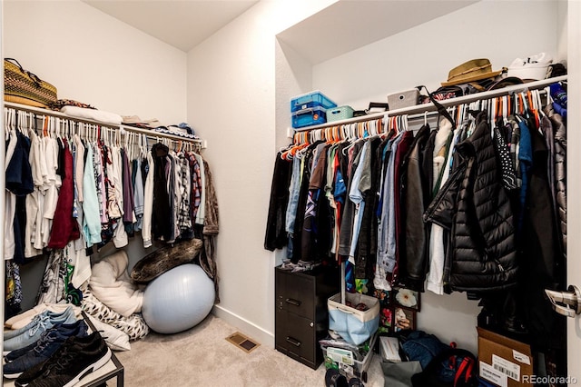 walk in closet featuring light carpet