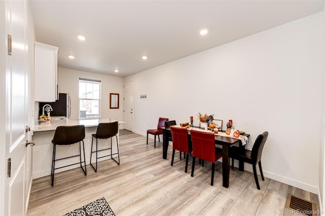 dining space with sink and light hardwood / wood-style floors