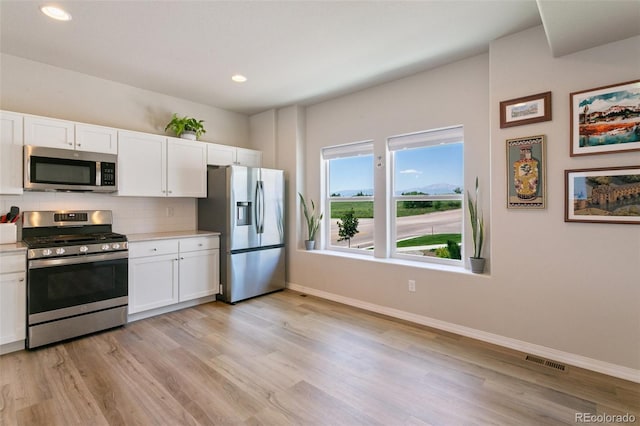 7407 Rufous Fronted Vw, Colorado Springs, CO 80923 - kitchen with appliances with stainless steel finishes, white cabinets, backsplash, light countertops, and recessed lighting