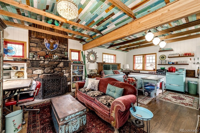 12346 Bear Haven Rd, Conifer, CO 80433 - living area featuring wood finished floors, a stone fireplace, a chandelier, beamed ceiling, and wood walls