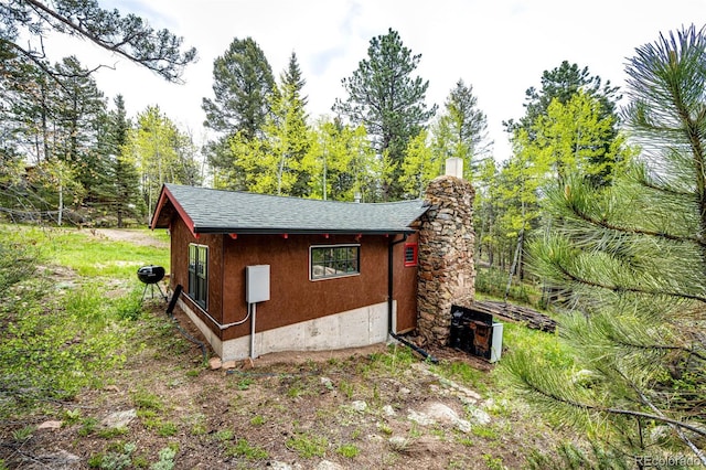 12346 Bear Haven Rd, Conifer, CO 80433 - view of property exterior with a chimney and roof with shingles