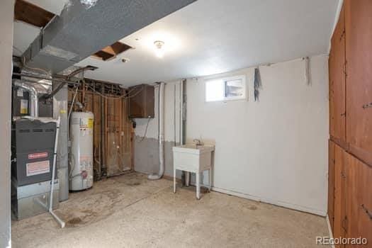 basement featuring sink and water heater