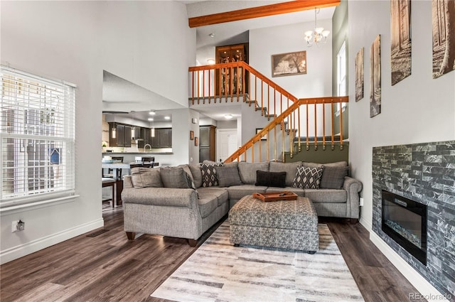 943 S Fairplay St, Aurora, CO 80012 - living area featuring dark wood-style floors, stairs, a chandelier, a glass covered fireplace, and baseboards