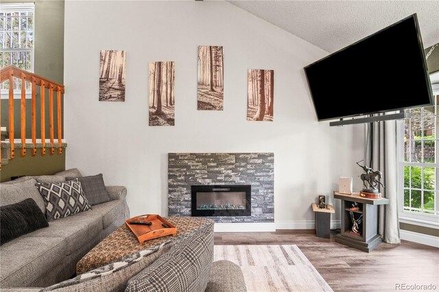 943 S Fairplay St, Aurora, CO 80012 - living area with wood finished floors, a fireplace, baseboards, and lofted ceiling